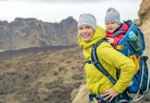 Babytragen und Tragetücher – was Sie beachten sollten Mutter mit Kind in Rückentrage