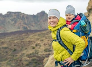 Babytragen und Tragetücher – was Sie beachten sollten Mutter mit Kind in Rückentrage