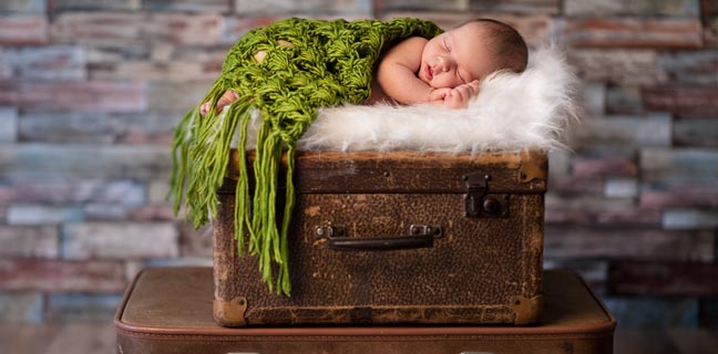 Süsses Baby schläft auf einem Koffer