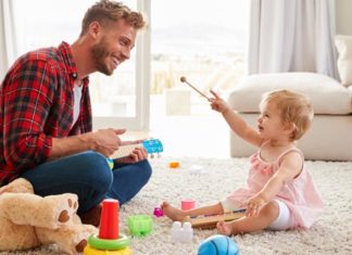 Wieviel Spielzeug braucht ein Kind? Vater und Tochter mit Kinderspielzeug